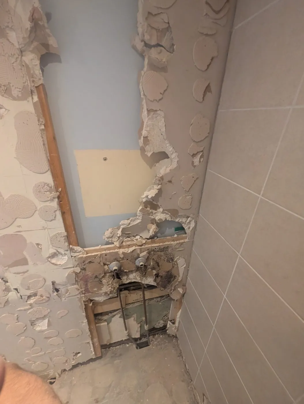 Lille Road wall opened behind the old shower valve showing damaged studwork