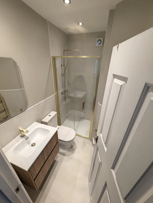 Lille Road shower room with brushed-brass bifold enclosure