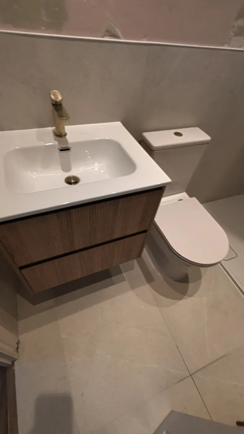 Fluted vanity unit and brushed-brass basin tap at Lille Road