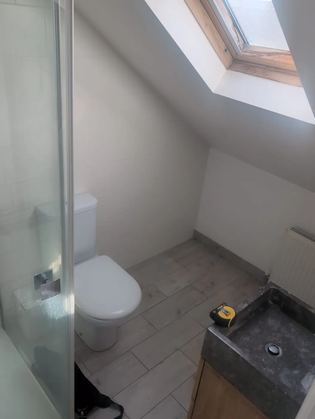 Rosaline Road loft en-suite before, with white tiles and chrome fittings under a sloping ceiling
