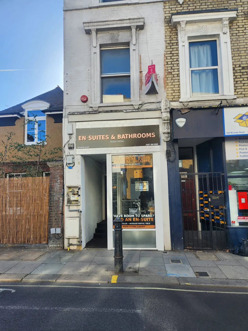 En-Suites & Bathrooms shop at 287 Munster Road, Fulham, with fascia sign and window posters